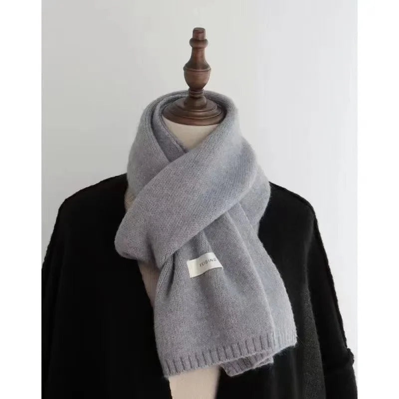 Women's narrow knitted scarf with ribbed ends and a small white label - grey