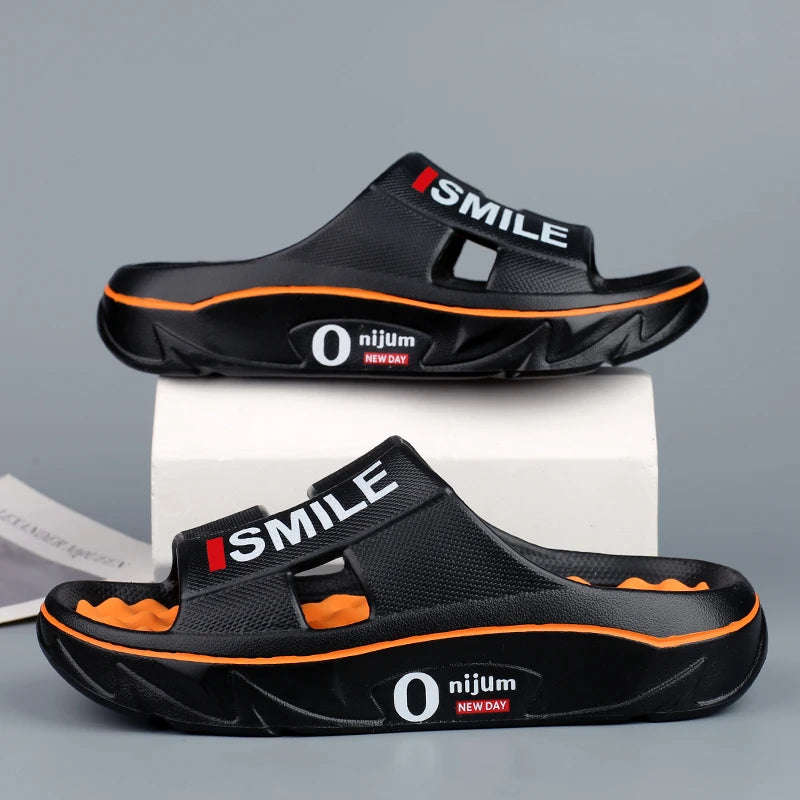 Sliders in EVA with a nubbed footbed, wide cut-out strap and thick sole - black/orange