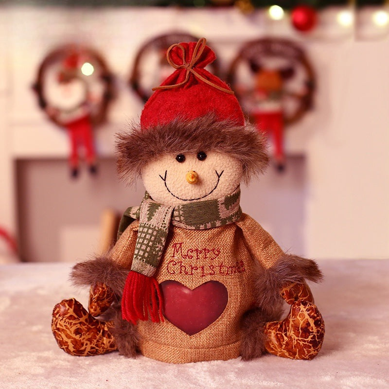 Seated plush Christmas figure with hat, scarf and a heart-shaped window in the body - snowman