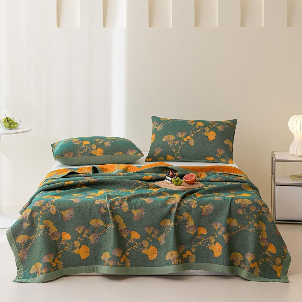 Quilted bedspread with a ginkgo leaf print on a made bed - with pillowcase