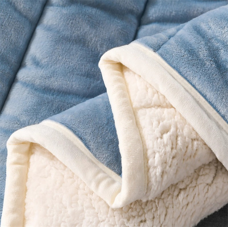 Quilted flannel fleece blanket with a sherpa reverse on a bed - view 2