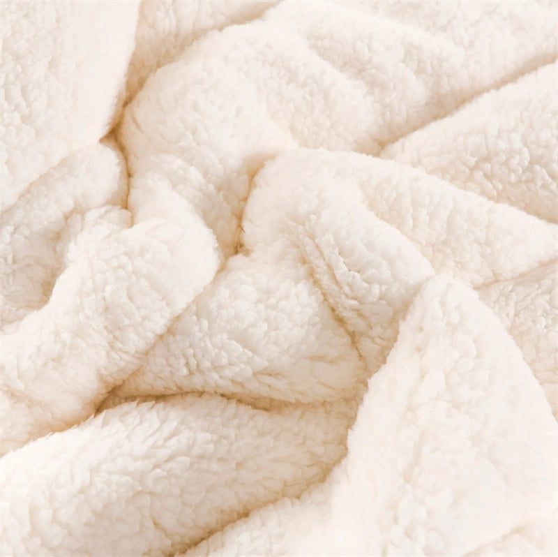 Quilted flannel fleece blanket with a sherpa reverse on a bed - view 3