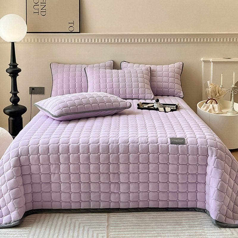 Quilted teddy bedspread with a square pattern on a double bed - lilac