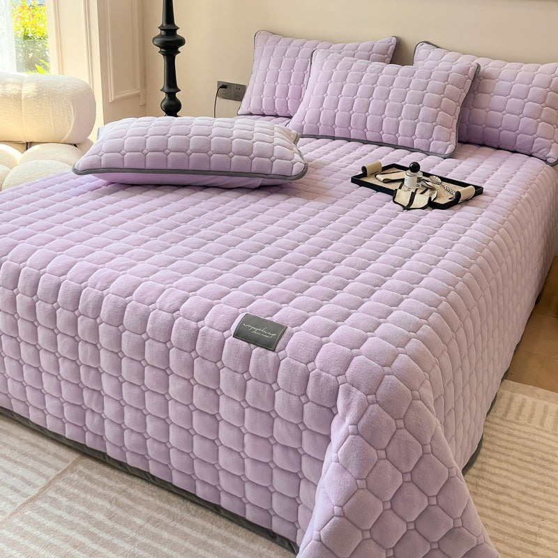 Quilted teddy bedspread with a square pattern on a double bed - lilac