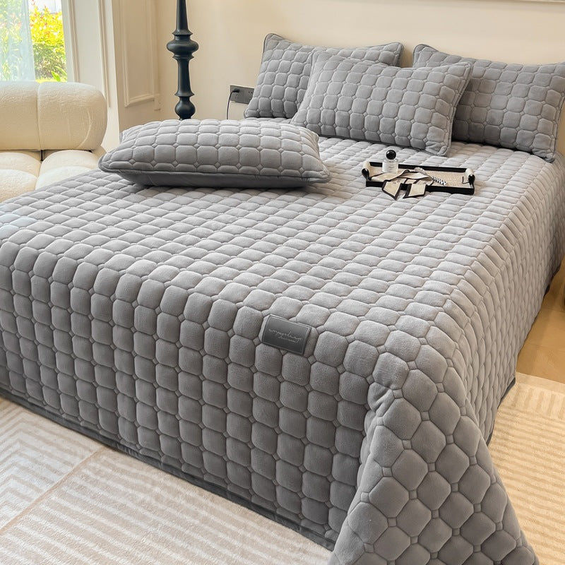 Quilted teddy bedspread with a square pattern on a double bed - grey