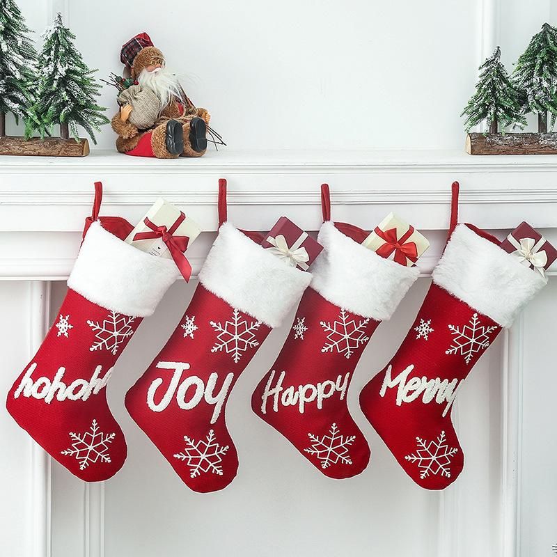 Red Christmas stocking with a white plush cuff, snowflakes and lettering