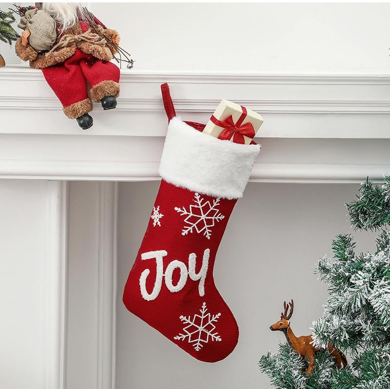 Red Christmas stocking with a white plush cuff, snowflakes and lettering