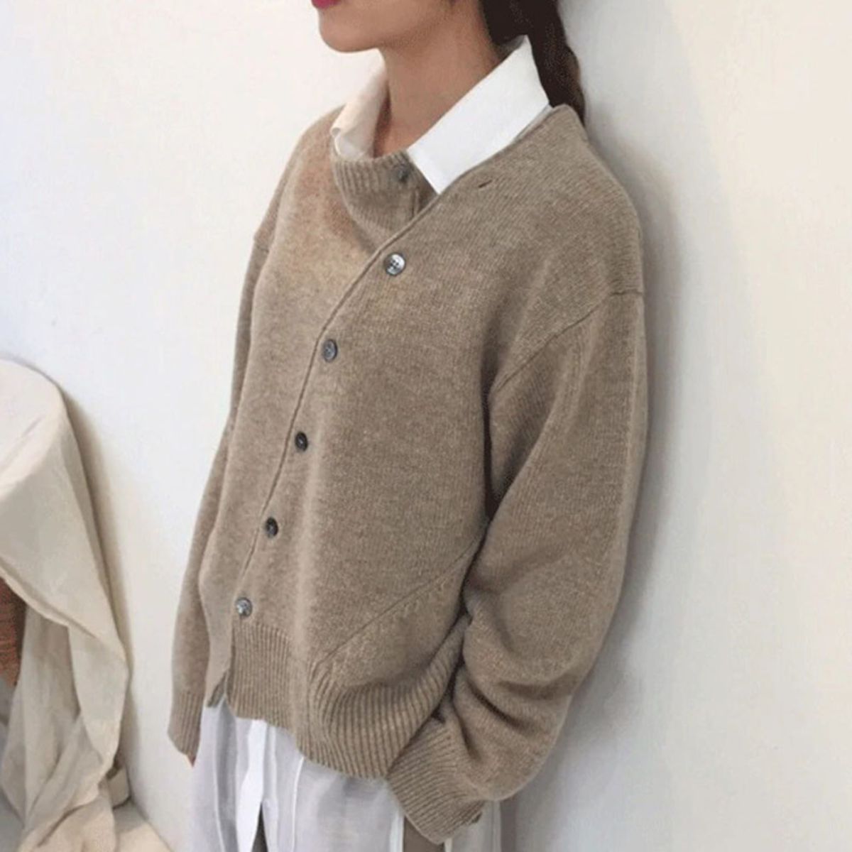 Women's relaxed knit cardigan with a round neck and asymmetric button front