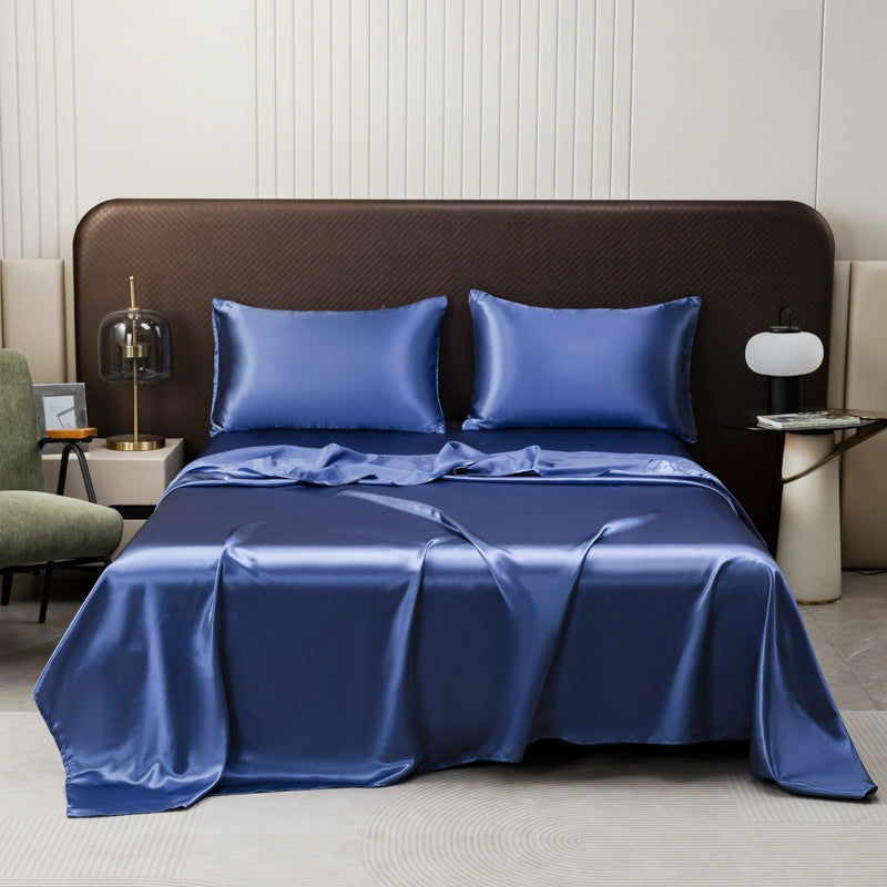 Satin sheet set with fitted sheet, flat sheet and two pillowcases on a bed - cobalt blue