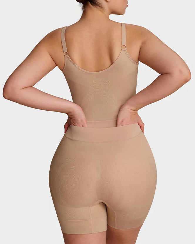 Seamless shapewear bodysuit with thin adjustable straps and legs to mid-thigh