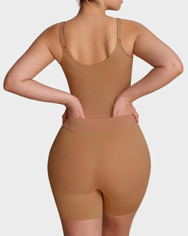 Seamless shapewear bodysuit with thin adjustable straps and legs to mid-thigh
