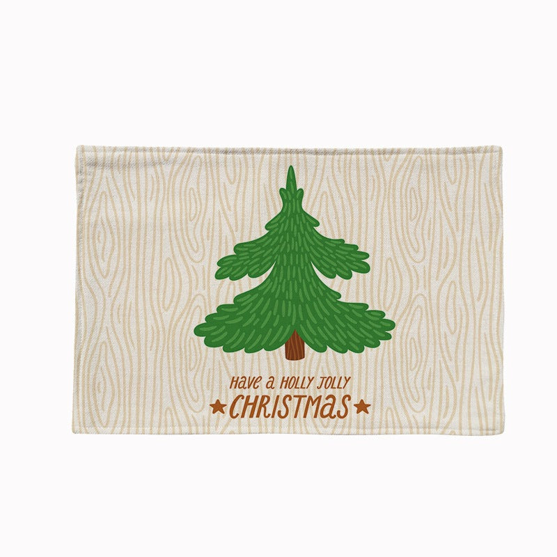 Set of four Christmas placemats with a festive print on a laid table - christmas tree on cream