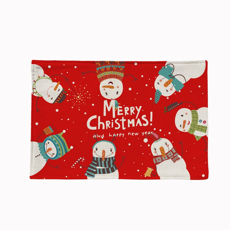 Set of four Christmas placemats with a festive print on a laid table - snowmen on red
