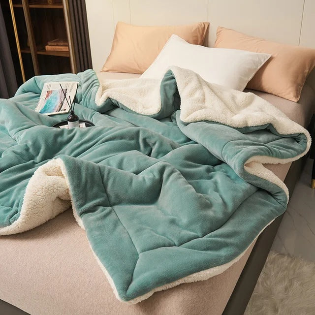 Sherpa blanket with quilted channels on a made bed - teal