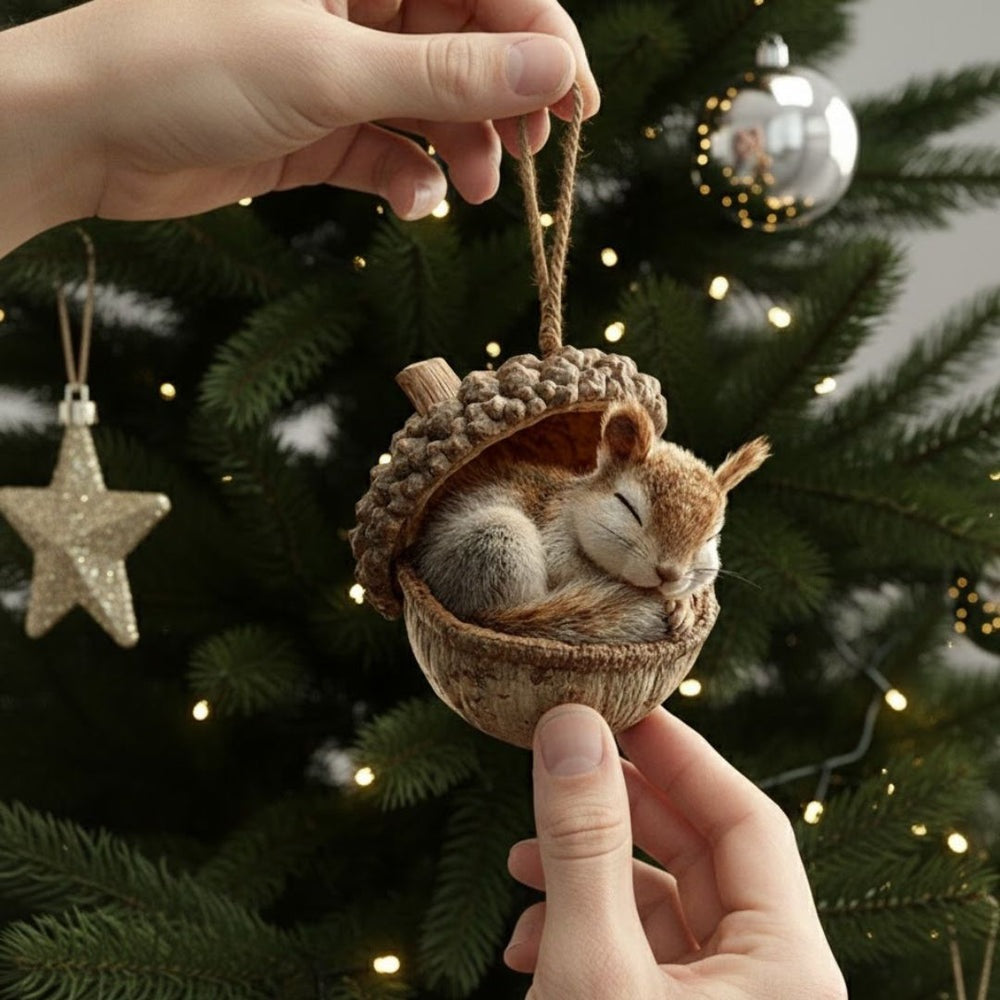 Flat acrylic Christmas ornament printed with a sleeping animal in an acorn, hanging on a tree