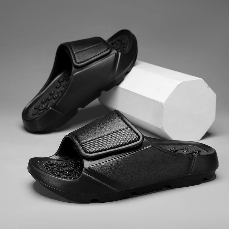 EVA sliders with a wide adjustable strap, a footbed of small nubs and a thick sole - black
