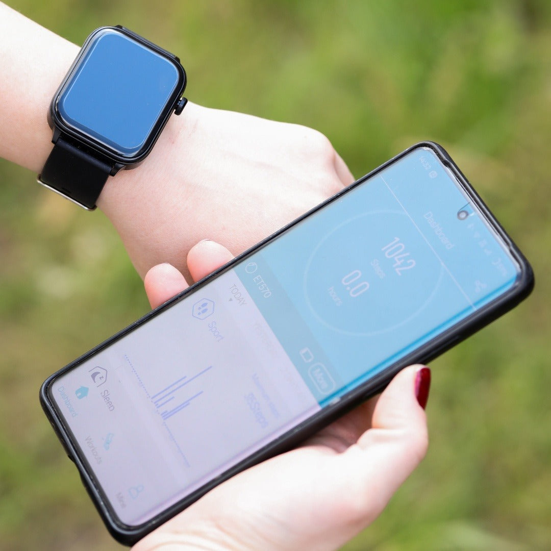 Smartwatch with a blue strap next to a phone showing the app