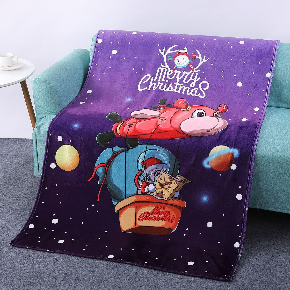 Soft Christmas blanket with a festive print, draped over a sofa - purple father christmas balloon