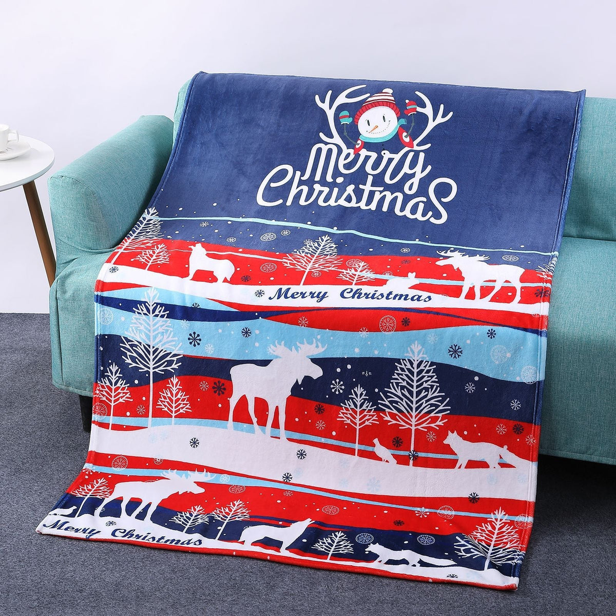 Soft Christmas blanket with a festive print, draped over a sofa - navy moose stripes