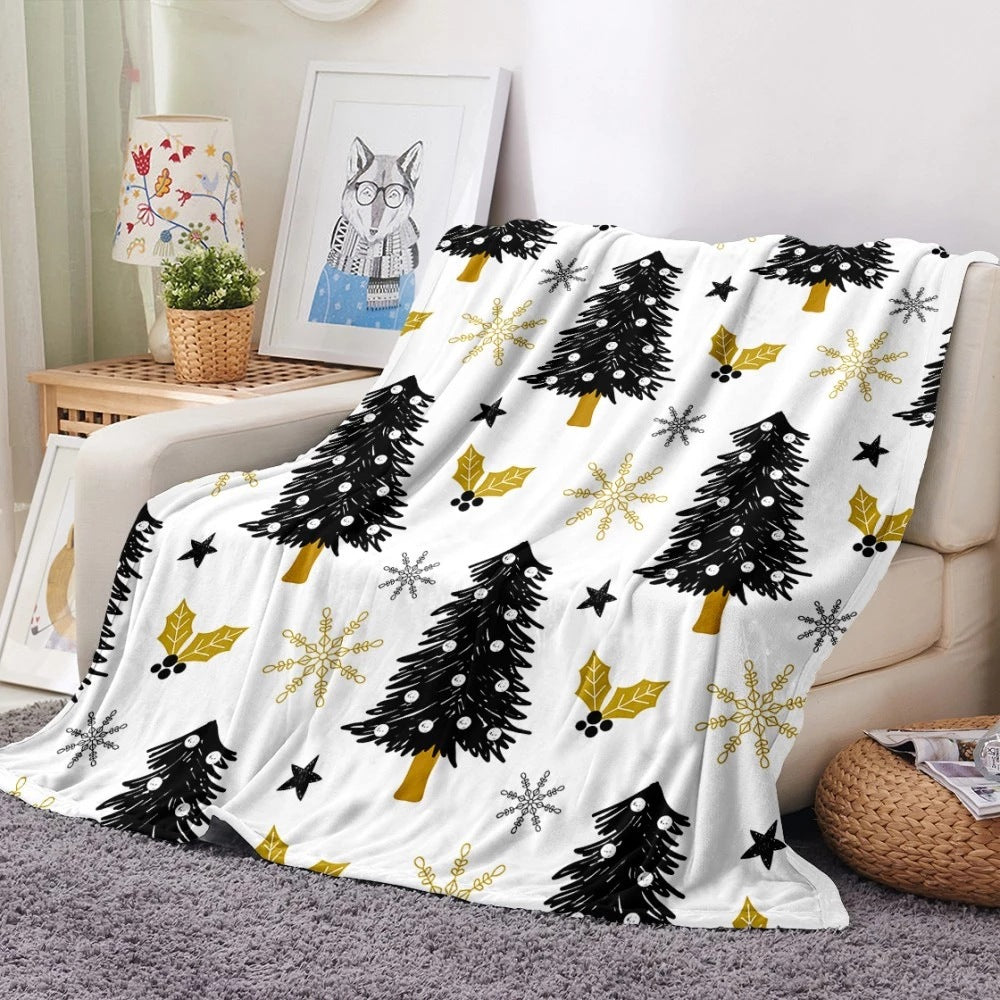 Soft fleece Christmas blanket with an all-over festive print on a sofa - white with black trees