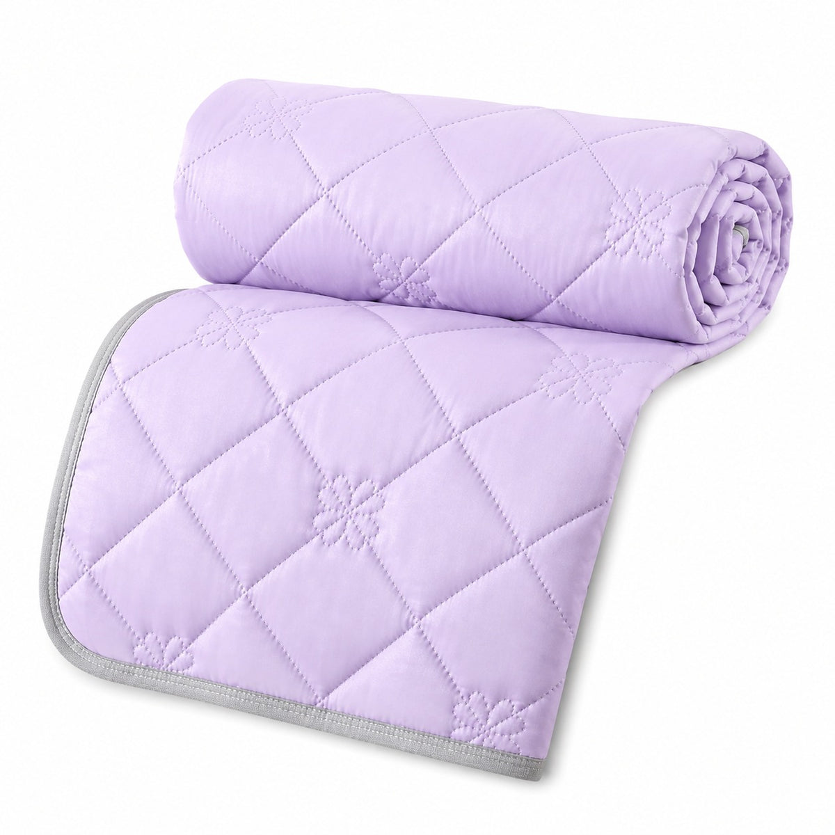 Reversible summer blanket with diamond and floral stitching on a bed - lilac