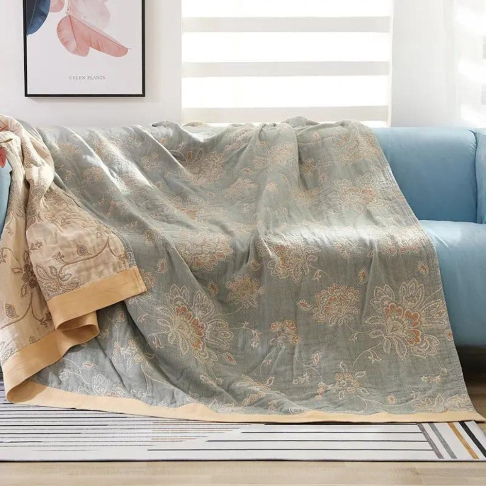 Summer blanket with a jacquard floral pattern over a sofa - sage green