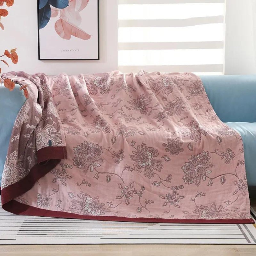 Summer blanket with a jacquard floral pattern over a sofa - dusty pink