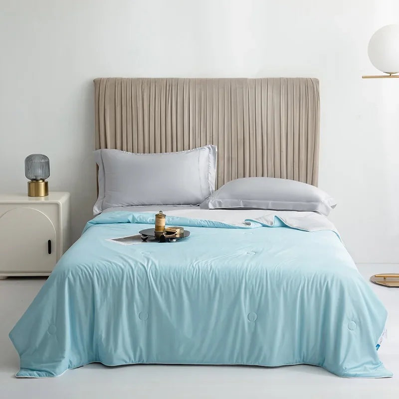 Reversible summer blanket with a grey underside on a double bed - sky blue