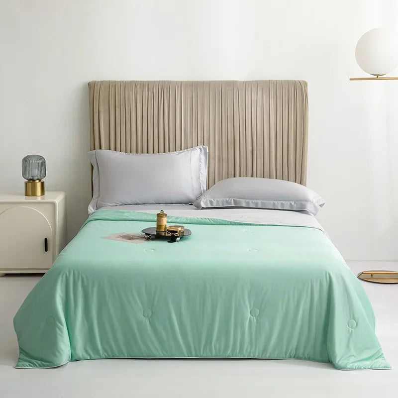 Reversible summer blanket with a grey underside on a double bed - mint green
