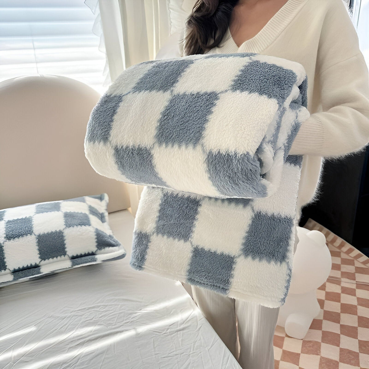 Teddy fleece blanket with a checkerboard pattern, folded in someone's arms - slate blue