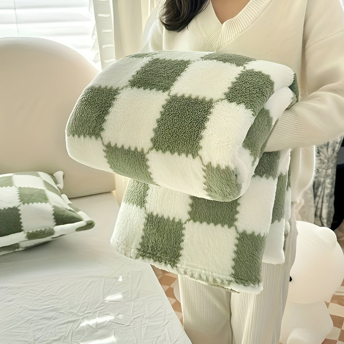 Teddy fleece blanket with a checkerboard pattern, folded in someone's arms - olive green