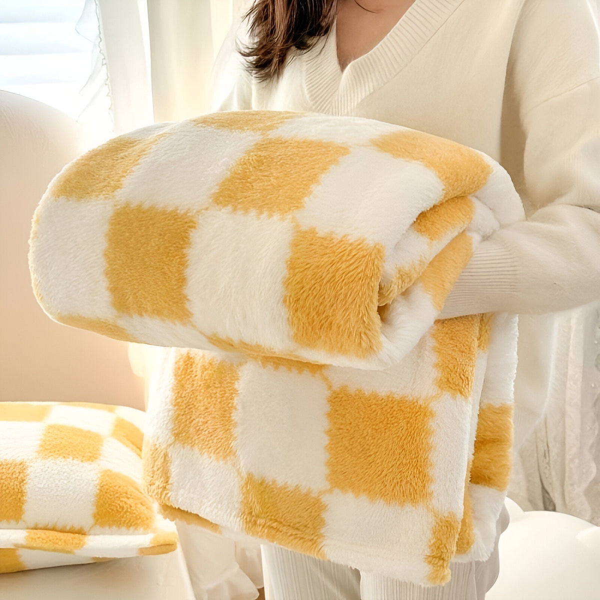 Teddy fleece blanket with a checkerboard pattern, folded in someone's arms - ochre
