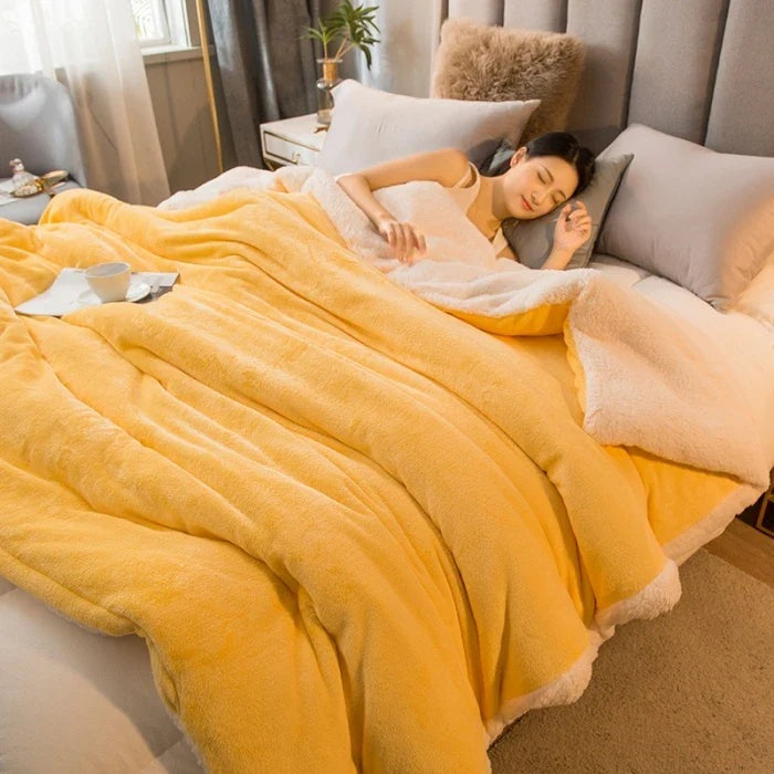 Thick sherpa blanket with a velvet-soft side on a bed - yellow