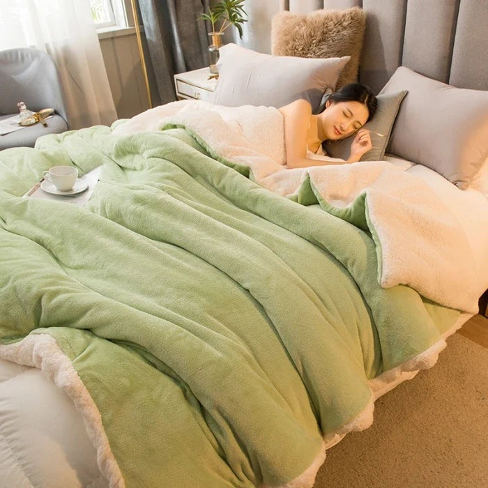 Thick sherpa blanket with a velvet-soft side on a bed - light green