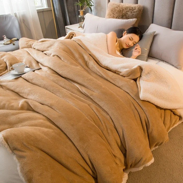 Thick sherpa blanket with a velvet-soft side on a bed - camel