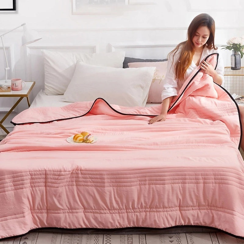 Thin quilted summer blanket with piping on a made bed - view 3