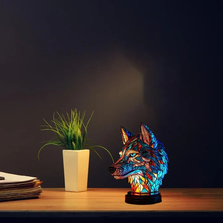 Wolf head lamp in a stained glass look in blue and orange with light blue eyes on a round base