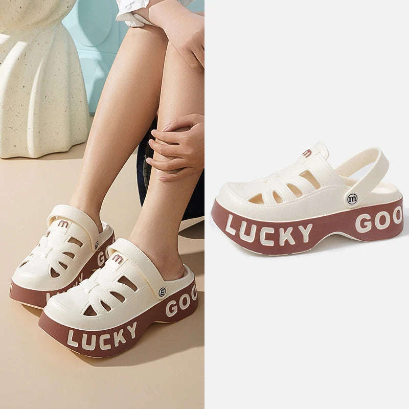 Closed-toe sliders with cut-outs, pivoting heel strap and thick platform sole with lettering - white