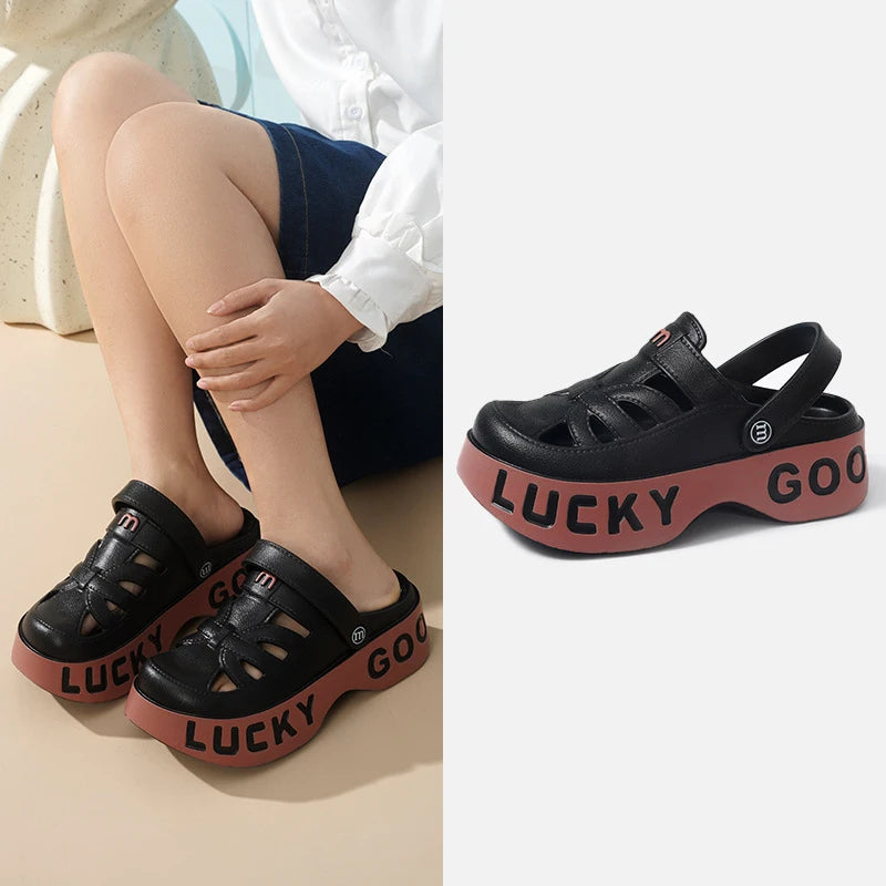 Closed-toe sliders with cut-outs, pivoting heel strap and thick platform sole with lettering - black